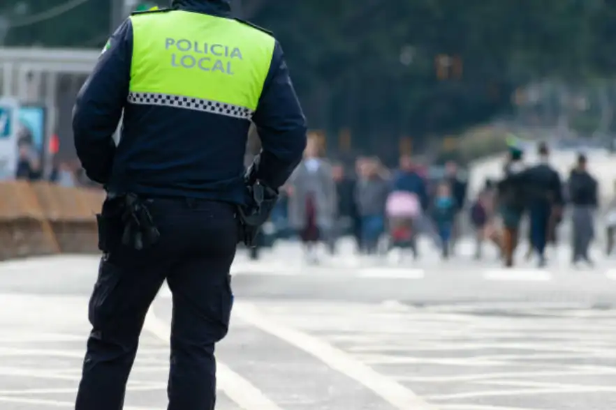 Agente de Policía Local en primer plano con formación al fondo